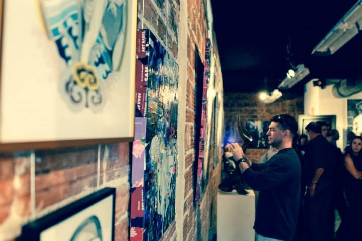 Derek Gores Gallery Guest Viewing Art on Wall