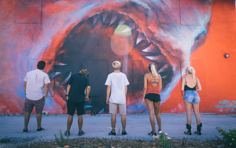 A group of people looking at the Shark Toof mural in the Eau Gallie Arts District