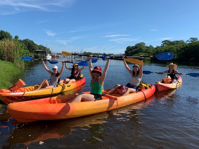 A group is kayaking on the Eau Gallie River on rented kayaks from Ballard Boards in Melbourne, FL