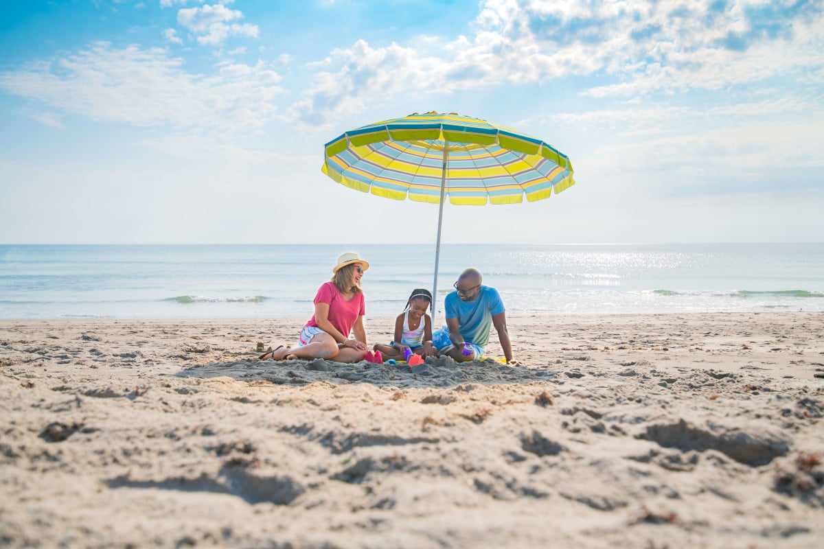 a family under an umbrella at Cocoa Beach